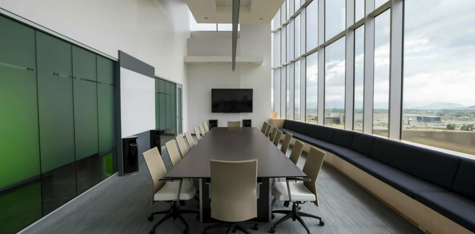Long boardroom table beside a wall of windows